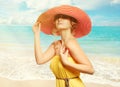 Beautiful girl in a hat enjoying the sun on the beach. Royalty Free Stock Photo