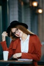 Beautiful girl with Hat and glasses with coffee and a magazine Royalty Free Stock Photo