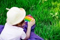 A beautiful girl in a hat, playing with a toy to drink on the green grass.in the park, on a summer day