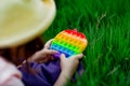 A beautiful girl in a hat, playing with a toy to drink on the green grass.in the park, on a summer day