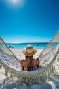 Beautiful girl in hat on sandy beach. Woman on seashore relaxing on swing on vacation