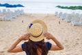 Beautiful girl in a hat sits with her back on a sandy beach Royalty Free Stock Photo