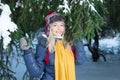 Beautiful girl in hat stands near green fir tree outdoor Royalty Free Stock Photo