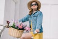 beautiful girl in hat sunglasses and denim jacket riding bicycle Royalty Free Stock Photo