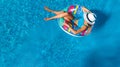 Beautiful girl in hat in swimming pool aerial top view from above, woman relaxes and swims on inflatable ring donut and has fun