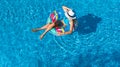 Beautiful girl in hat in swimming pool aerial top view from above, woman relaxes and swims on inflatable ring donut and has fun