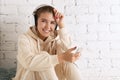 Beautiful  girl with headphones holding smartphone in  sportive outfit Royalty Free Stock Photo