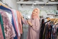 a beautiful girl in a headscarf smiling at the camera while holding a robe and smartphone Royalty Free Stock Photo