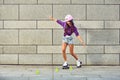 Beautiful girl in a helmet learns to ride on roller skates holding balance Royalty Free Stock Photo