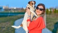 Beautiful girl with her friend Jack Russell dog walking in the park Royalty Free Stock Photo