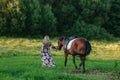 Beautiful girl with her horse on a lovely meadow lit by warm light Royalty Free Stock Photo