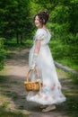 Beautiful girl in an historical bride dress with a wicker basket in her hands Royalty Free Stock Photo