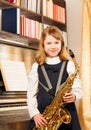 Beautiful girl holding alto saxophone indoors Royalty Free Stock Photo