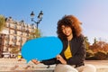 Beautiful girl holding blue blanked speech bubble Royalty Free Stock Photo