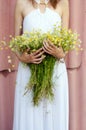 Beautiful girl holding bouquet of camomille flowers in summer Royalty Free Stock Photo