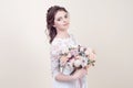 Beautiful girl holding a bouquet of flowers wearing in luxurious wedding dress isolated on background