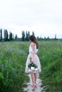 Beautiful girl holding a bouquet of pink peonies flowers. Back view. Girl with flowers. Girl with peonies, enjoying a bouquet of f Royalty Free Stock Photo