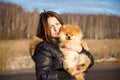 Beautiful girl holding a dog Spitz. Small breeds.