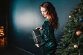 Beautiful girl holding gift box near Christmas tree Royalty Free Stock Photo