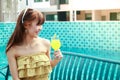 A beautiful woman with a glass of orange juice by the pool Royalty Free Stock Photo