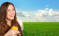 beautiful girl holding a glass of juice and smiling on the background of the field Royalty Free Stock Photo