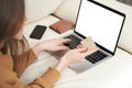 Beautiful girl holding gold credit card in hands and using laptop computer to perform shopping online by inputting card Royalty Free Stock Photo