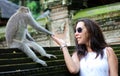 Beautiful girl holding hands with monkey at monkeys forest in Bali Indonesia, pretty woman with wild animal.