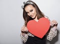 Beautiful girl holding large paper red heart. Heartbreaker. Temptress. Seductive woman. Portrait of funny pinup young fashion Royalty Free Stock Photo