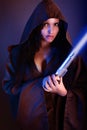 Beautiful girl holding a lightsaber