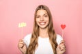 Beautiful girl holding red heart and love lettering isolated on pink