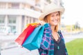 girl is holding shopping bags, looking at camera and smiling while walking down the street Royalty Free Stock Photo