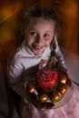 Beautiful girl holds Easter cake and eggs on a plate and smiling at the camera. Easter holiday Royalty Free Stock Photo