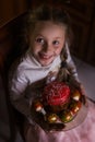 Beautiful girl holds Easter cake and eggs on a plate and smiling at the camera. Easter holiday Royalty Free Stock Photo