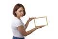 Beautiful girl holds a light wooden frame Royalty Free Stock Photo