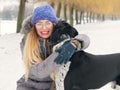 Beautiful girl hugging a dog in the snow
