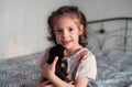 A beautiful girl hugs a little rottweiler puppy. Child and puppy. Happy childhood and favorite pet