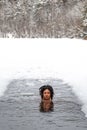 Beautiful girl on the ice enjoying winter in the cold water