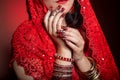 Beautiful girl in the image of Indian woman in a red sari with beautiful patch acrylic nails in oriental style in the studio Royalty Free Stock Photo