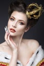 Beautiful girl in the image of the Queen in the mantle with a crown on the head and long nails. Beauty face. Royalty Free Stock Photo