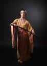 Beautiful girl in kimono with japanese sword katana on a black Royalty Free Stock Photo