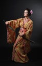 Beautiful girl in kimono with japanese sword katana on a black Royalty Free Stock Photo