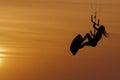 Beautiful girl kitesurfing jump at golden hour womanl jumping kiteboarding silhouette at sunset Royalty Free Stock Photo