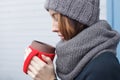 Beautiful girl in a knitted cap and mittens freezing in winter