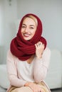 Beautiful girl knitting in cozy flat wearing casual clothes, big deep red scarf.