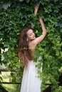 Beautiful girl leaning on a moss wall