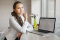 Beautiful girl leans her elbows on table with laptop Royalty Free Stock Photo