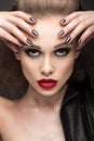 Beautiful girl in leather jacket with bright makeup and manicure Cat's Eye. Beauty face. Nail Design. Royalty Free Stock Photo
