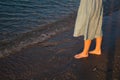 Beautiful girl legs in blue dress is walking on the sea beach. Summer vacation photo Royalty Free Stock Photo