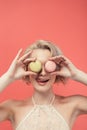 beautiful girl licking lips and holding two macarons in front of eyes, Royalty Free Stock Photo