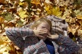 Beautiful girl lies on the leaves in the autumn park